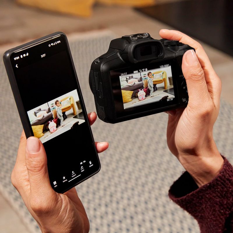 Canon EOS R100 spiegelloses Kamera Frau, die sich Fotos auf dem Produkt und einem Telefon ansieht