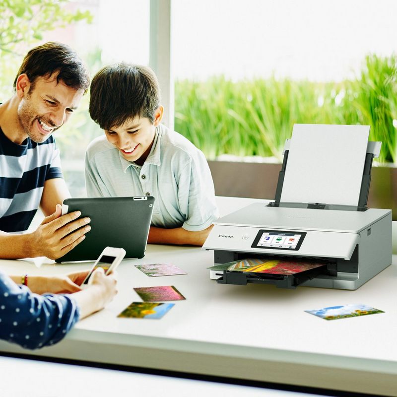 Familie, die die Zeit miteinander genießt und ein Foto über ein Tablet druckt