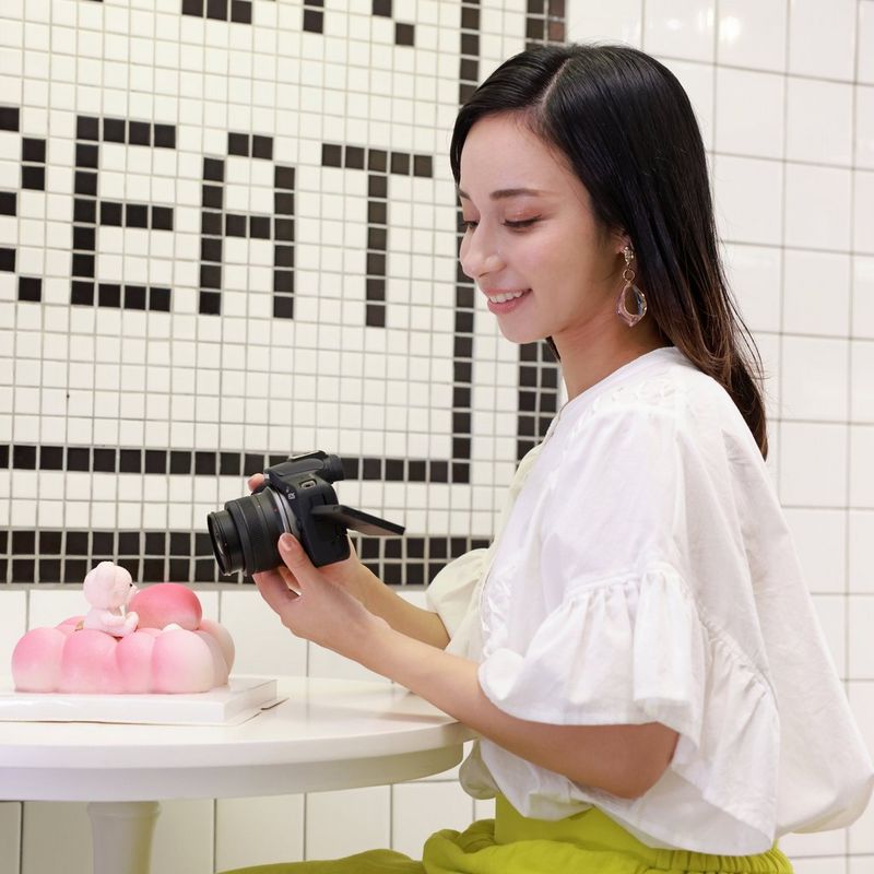 Canon RF-S 10-18mm F4.5-6.3 IS STM Objektiv Eine Person sieht sich ein Foto auf einer Kamera an, an der das Produkt angebracht ist