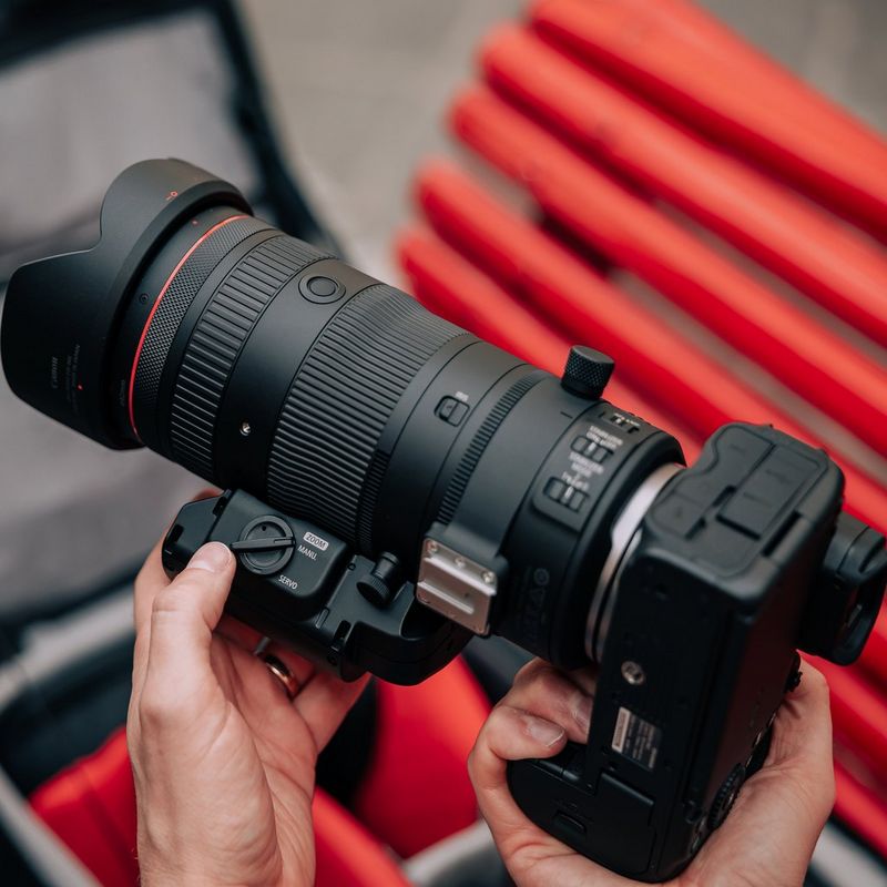 Canon Power Zoom Adapter PZ-E2 Mann, der das Produkt, das an einem Objektiv angebracht wurde, nutzt