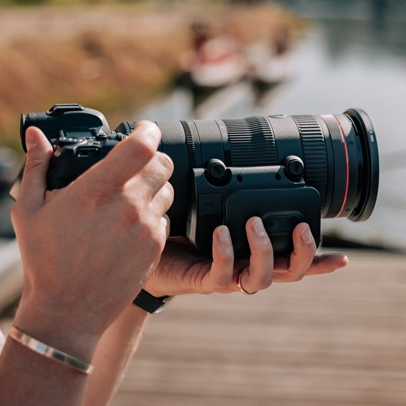 Canon Power Zoom Adapter PZ-E2 Mann, der ein Foto aufnimmt, während das Produkt an einem Objektiv angebracht wird