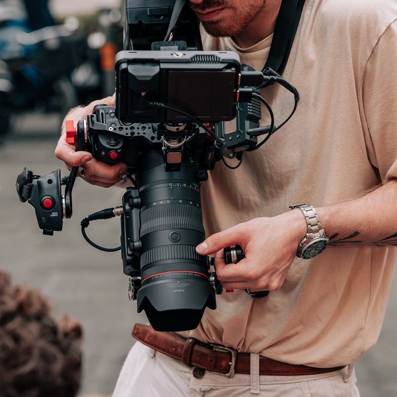 Canon Power Zoom Adapter PZ-E2B Produkt Mann, der eine Kamera verwendet, an dessen Objektiv das Produkt angebracht ist