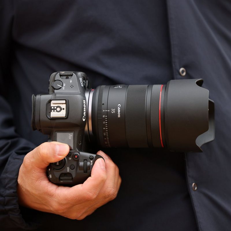 Canon RF 35mm F1.4L VCM Objektiv Mann, der eine Kamera mit angebrachtem Objektiv hält