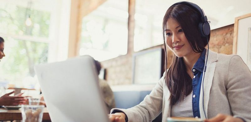 Dame sitter på kafe med pc