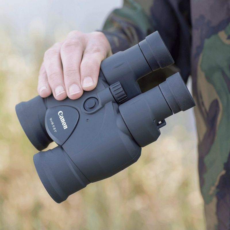 Canon 12x36 IS III Fernglas Mann, der ein Fernglas in der Hand hält