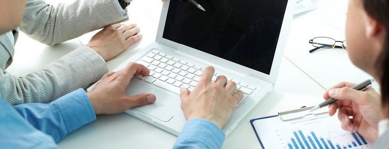 People gathered around a laptop