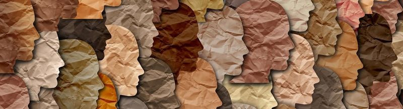 Featureless, slightly crumpled paper faces of all different skin tones, facing right and overlaid onto each other in a collage style