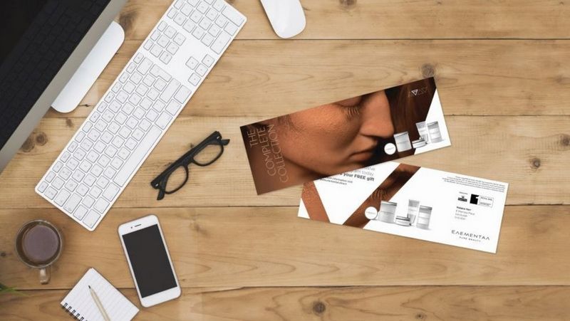 Mac, keyboard and stationary scattered on desk