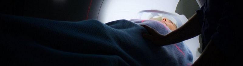 A woman entering a CT scanner