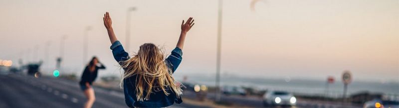 Two young women standing with their backs to the camera