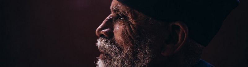 Side head and shoulders view of an Ethiopian monk in robes.