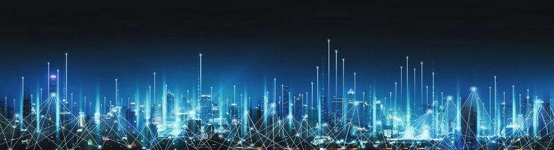 A panorama of a city at night, against a dark blue to light blue gradient background. Overlaid across the city are white connecting lines, to denote how everything is joined together in a smart city. And vertical white lights to symbolise connectivity of technology.