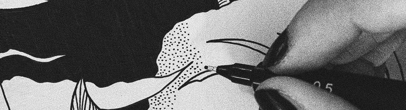 A hand with painted nails holds a fineliner pen and draws a black and white design © Chromakane/Jessie Cohen