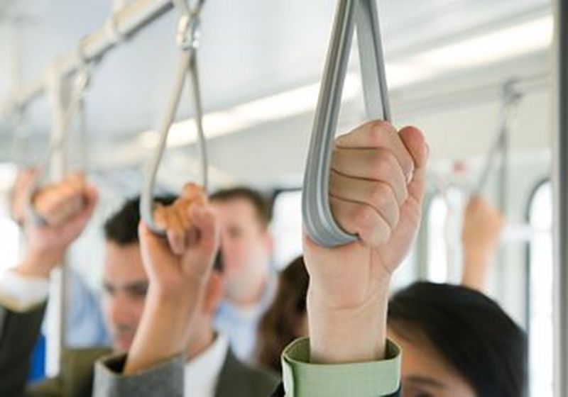 Three hands, one behind the other. Each is holding a hanging strap of the kind that is designed to keep them stable when standing on public transport.