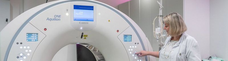 A female doctor pushes a button on Canon Aquilion ONE GENESIS CT Scanner