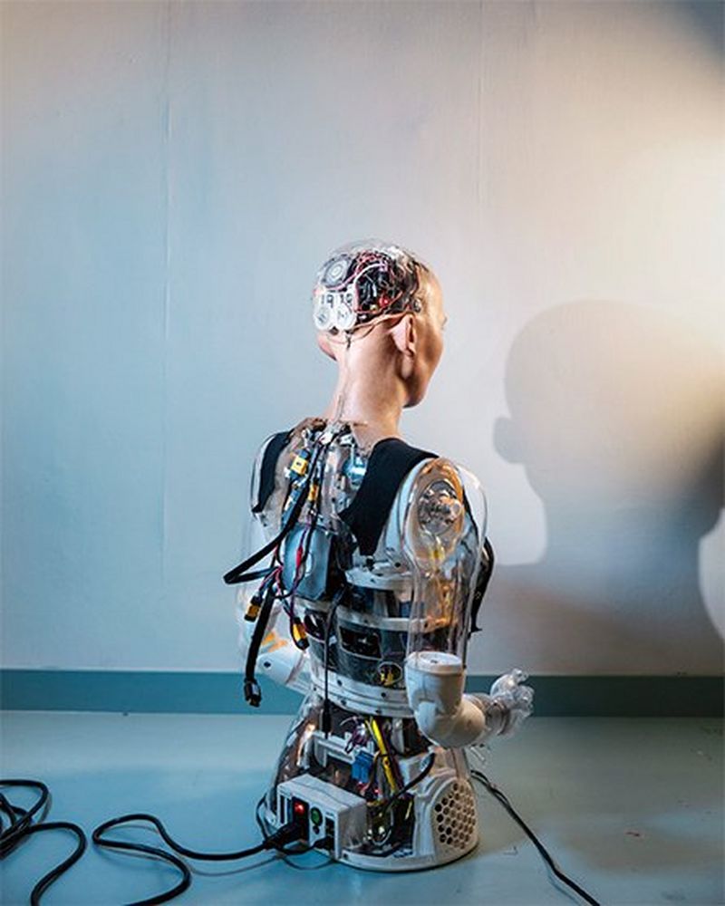 Sophia is seen from the back with her inner workings – a labyrinth of cables – exposed.