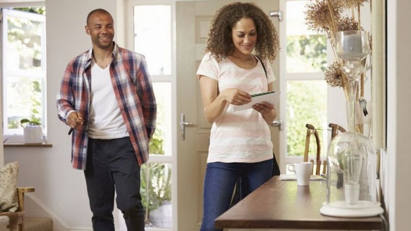 Couple looking at post after walking through front door
