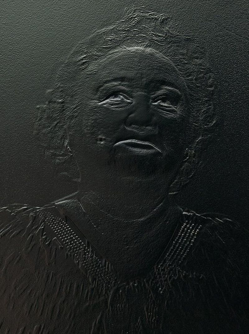 A photograph of a relief print. The print is a head and shoulders portrait of a woman with her head raised skywards.