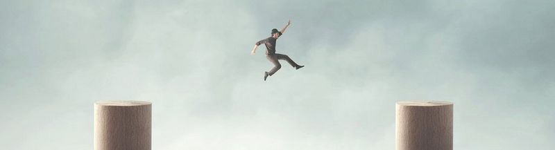 A man leaps from one pillar to another.