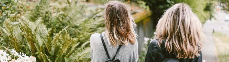 Two young women standing with their backs to the camera