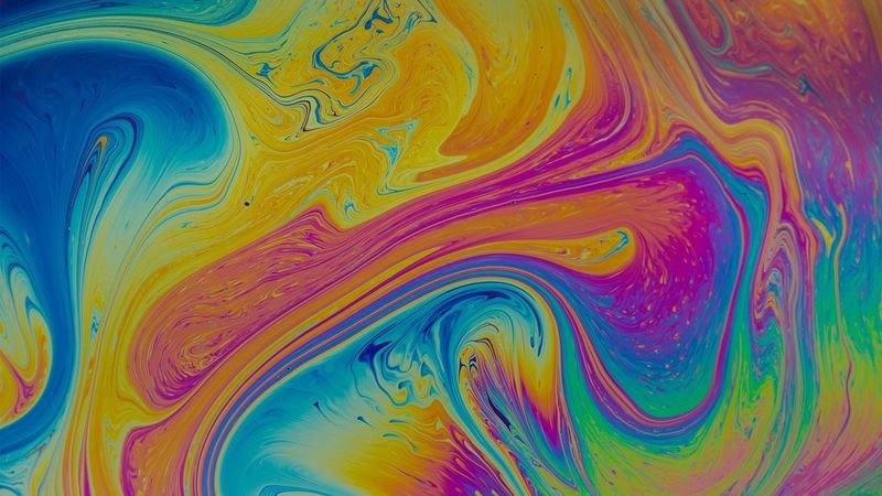 Swirling multicoloured patterns of soap in water. 