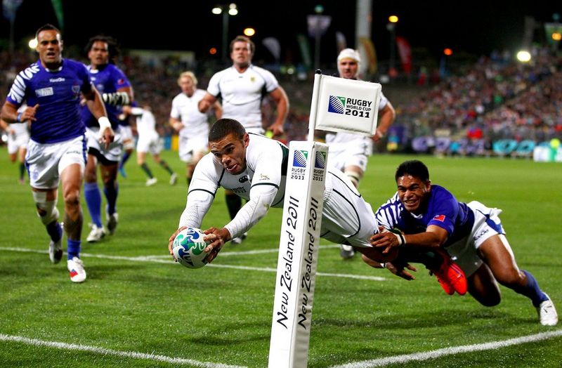 South Africa rugby player Bryan Habana dives to score a try, a Samoa rugby player grabbing his leg Photo by Hannah Peters.
