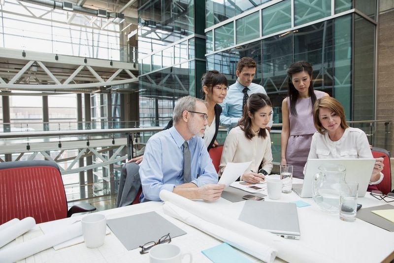 Group huddled round a laptop on desk