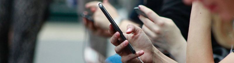 People sat, looking at their smartphones