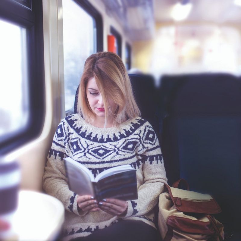 Girl reading book on train