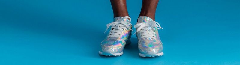 The feet of a model with silver shoes.