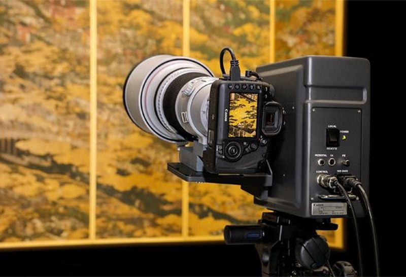 A Canon DSLR mounted and ready to photograph a piece of artwork