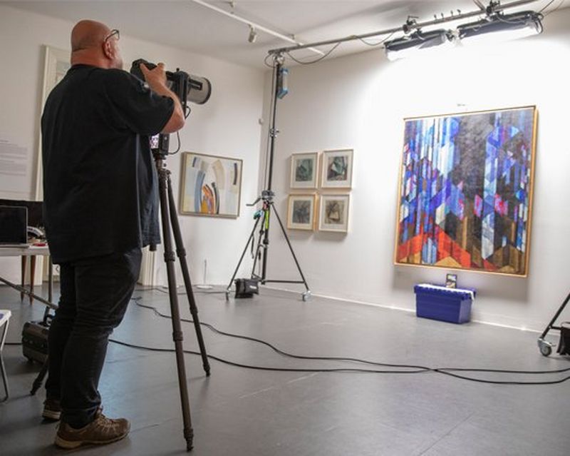 A man photographs a painting