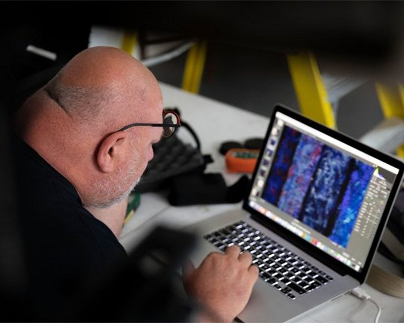 A man sits at a laptop, working.