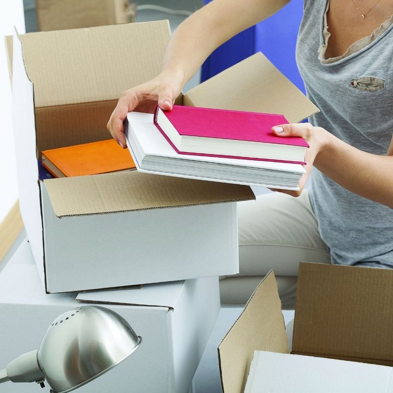 Girl unpacking books from box