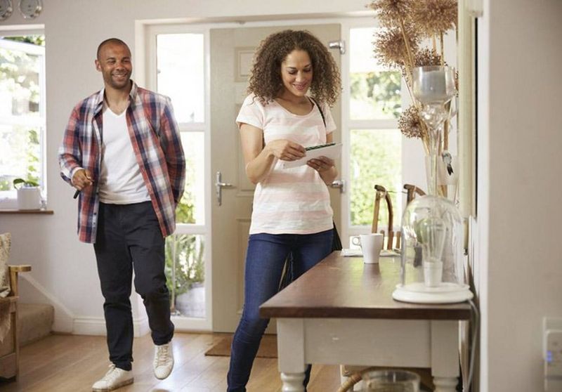 Man and woman looking at post as they arrive home