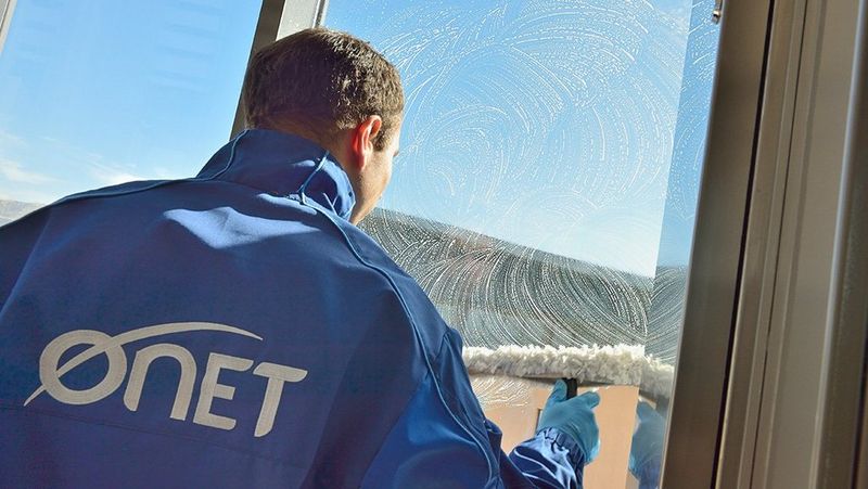 Man in shirt talks to man in high visibility jacket among rolls of electrical cabling in warehouse