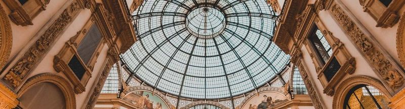 An ornate building from the inside, with a glass domed ceiling