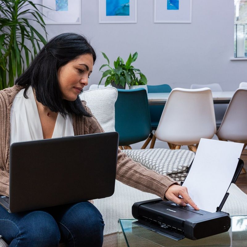 Canon PIXMA TR150 mobiler Tintenstrahldrucker mit Akku Produkt Schrägansicht mit einer Person, die den Drucker bedient