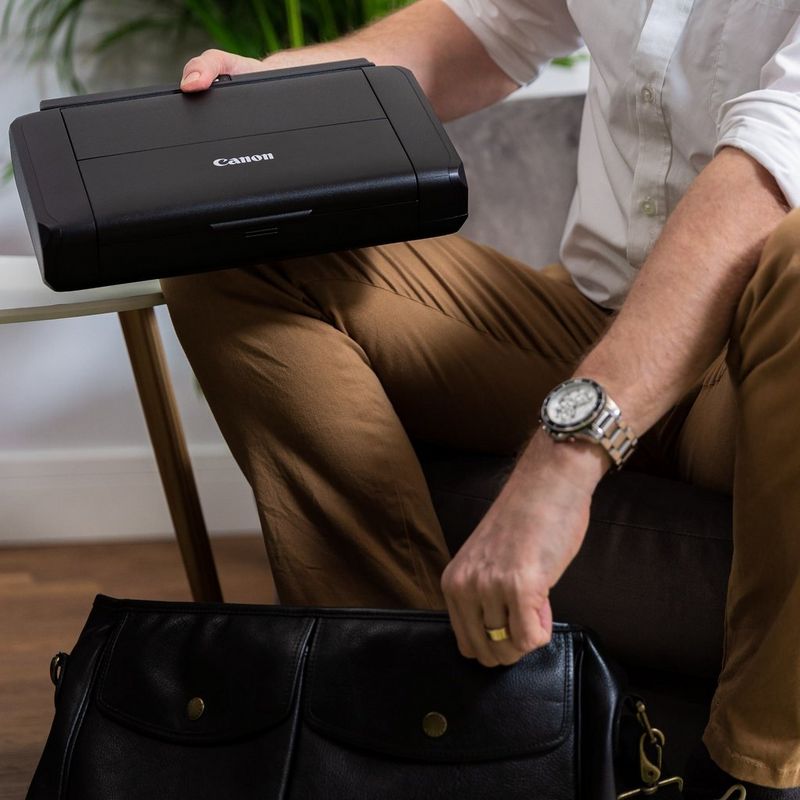 Canon PIXMA TR150 mobiler Tintenstrahldrucker mit Akku Produkt Eine Person, die den mobilen Drucker in der Tasche verstaut