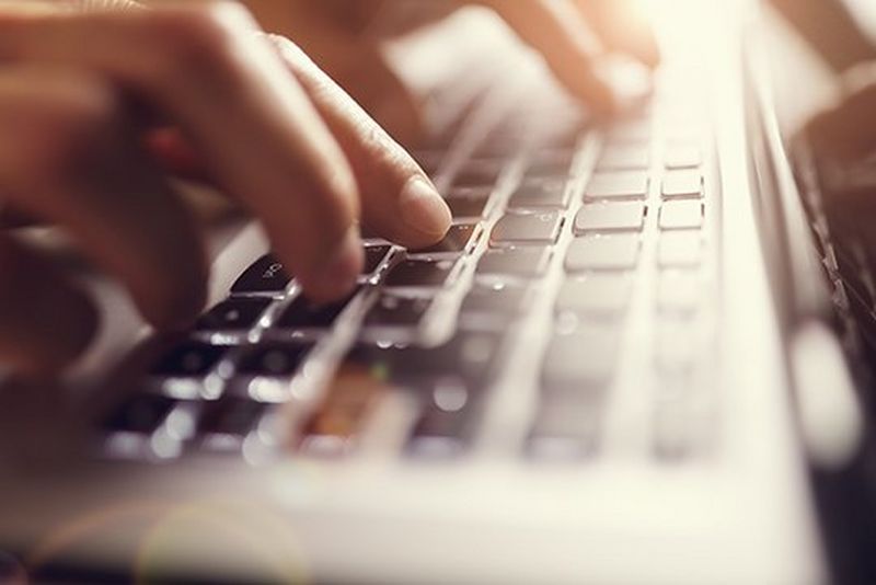 Close-up shot of fingers on a black keyboard.