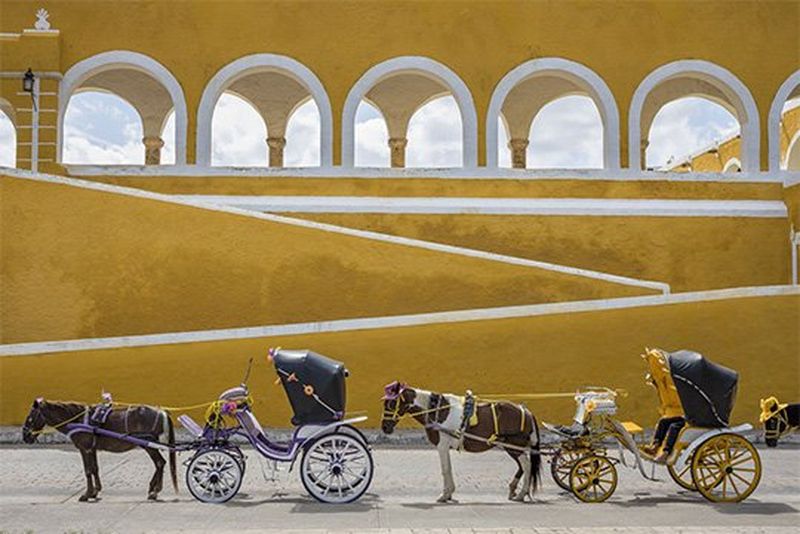 Horses and carriages awaiting passengers by the Convent in Izamal, Mexico.