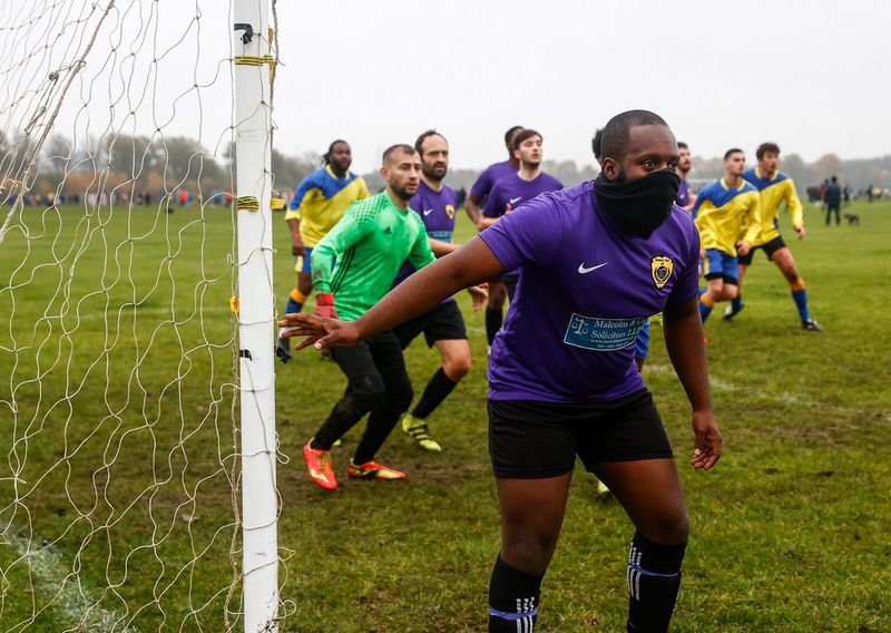Players prepare to defend an incoming shot during a game at Hackney Marshes, East London, England. 