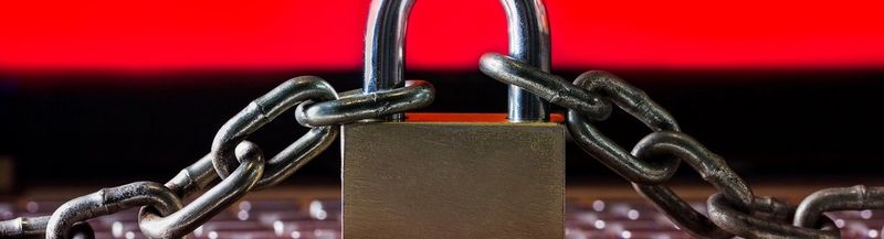 A padlock and chain on a red and black background.
