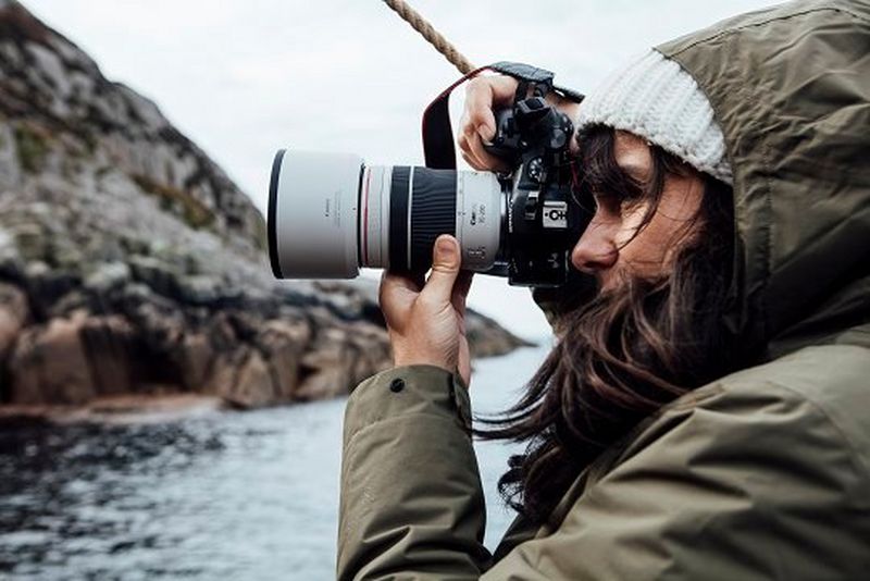 Lucia Griggi holding a Canon EOS R6 with a Canon RF 70-200MM F4L IS USM lens. 