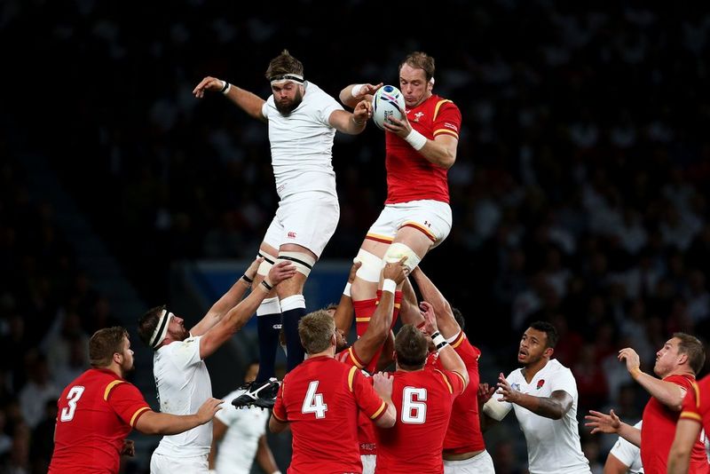 An Australian rugby player is tackled by an Irish rugby player.