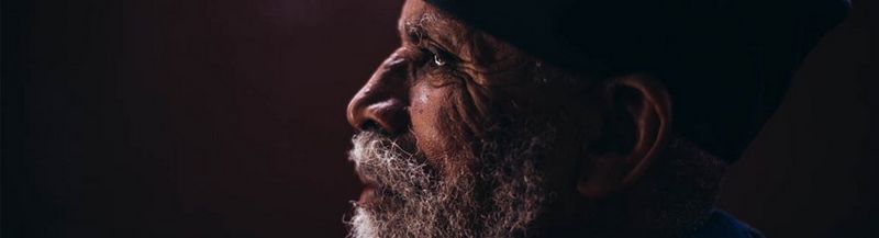 Side head and shoulders view of an Ethiopian monk in robes.