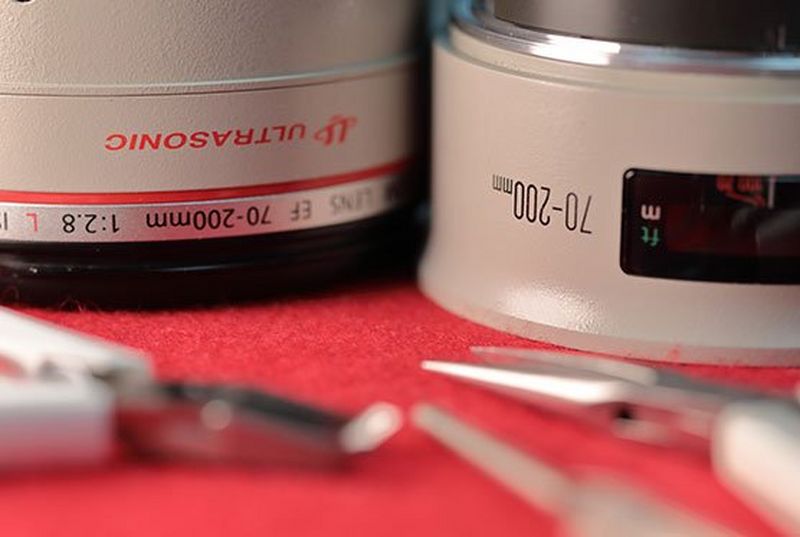 A Canon L lens with tools sitting on a repair table