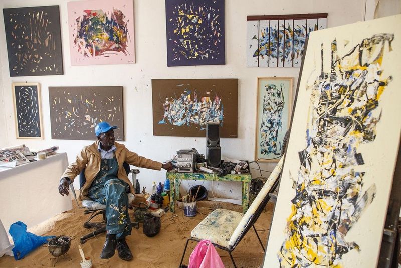 artist surrounded by his paintings