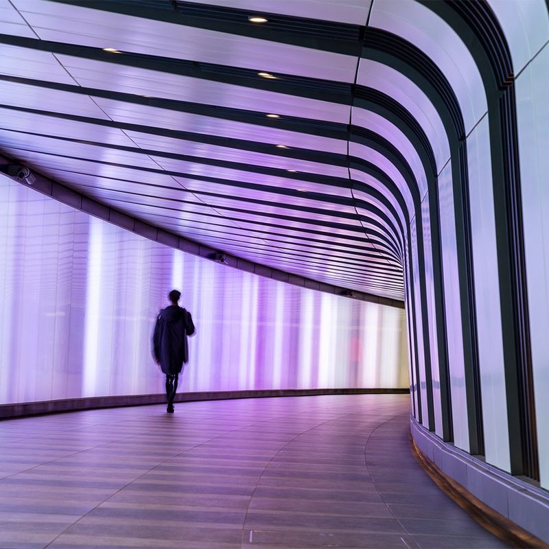 Person walks through pink lit corridor