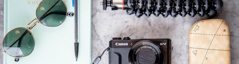 The tools of a vlogger. Camera, notebook, pen, sunglasses and gorilla pod.